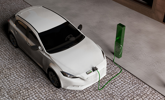 Electromobility. An electric car charging its batteries at the charging station on the street.