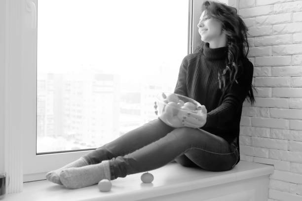 istock Girl at the window black and white 1186879132