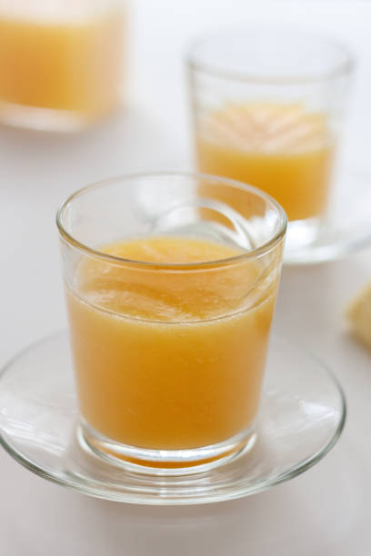 istock Two glasses of refreshing orange juice on a white table 1186880808