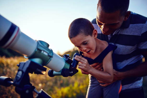 istock Father and son observing the sky with a telescope. 1186880983