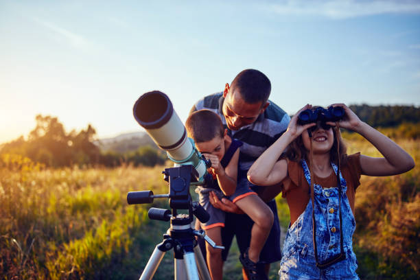 istock Father, daughter and son observing the sky with a telescope. 1186881204