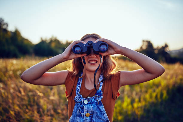 istock Little girl using binoculars in the nature. 1186882387