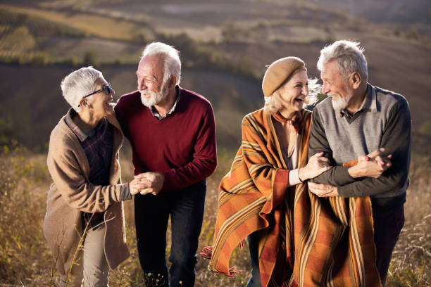 istock Happy mature couples talking while walking on the hill in autumn day. 1186882444