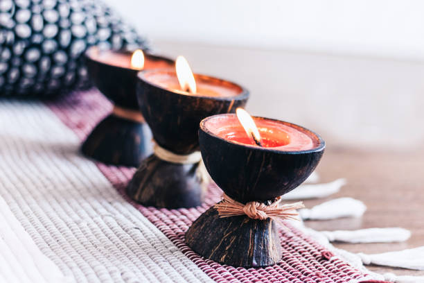istock Burning spa aroma candle in coconut shell on multi-colored rug background, cozy home interior 1186882747