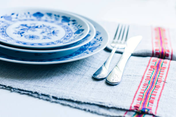 istock Table setting for dinner: a white plate, a fork, a knife on a woven cloth napkin with an embroidered pattern,  traditional handmade in Ukraine 1186882840