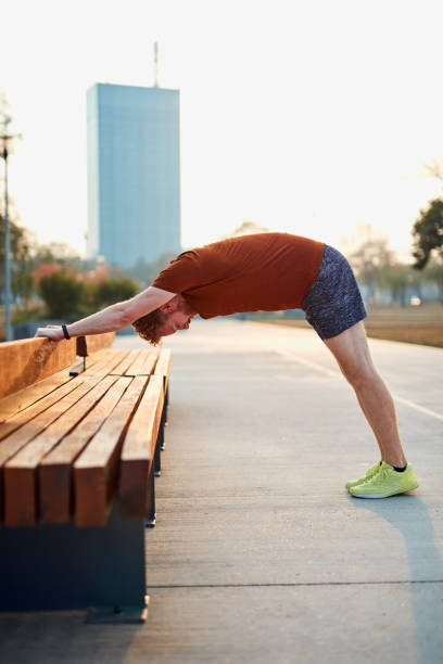 istock Young man exercising / stretching in urban park. 1186884156