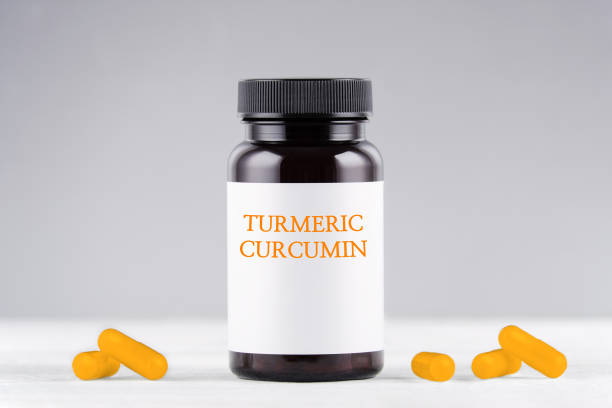 istock nutritional supplement turmeric curcumin bottle and capsules on gray 1186886758