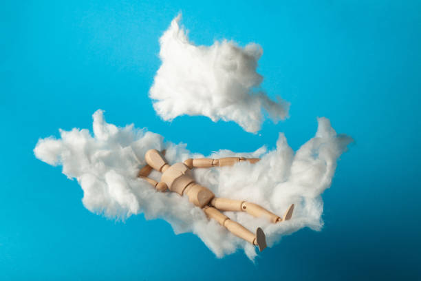 istock Napping toy man on comfortable cloud bed. Relax and dream 1186887217