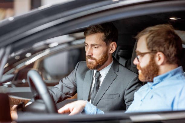 istock Sales manager with a client looking at the vehicle interior 1186888635