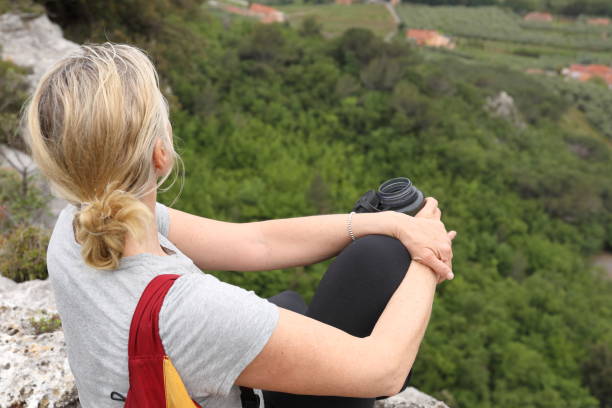 istock Female hiker relaxes above valley and drinks water 1186890506