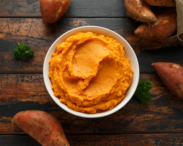 mashed sweet potatoes in white bowl on wooden rustic table. healthy food - yam imagens e fotografias de stock