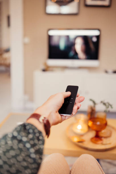 istock Hand with remote control infront of tv personal perspective 1186891899