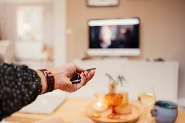 istock Hand with remote control infront of tv personal perspective 1186891948