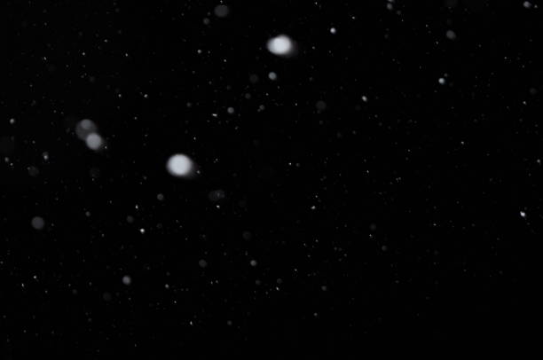 istock Overlay of real snow falling against the black night sky 1186893122