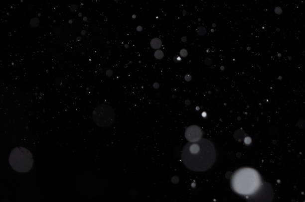 istock Overlay of real snow falling against the black night sky 1186893134