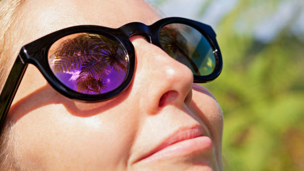istock Woman wearing sunglasses with palms, sky reflection in mirror lens 1186894207