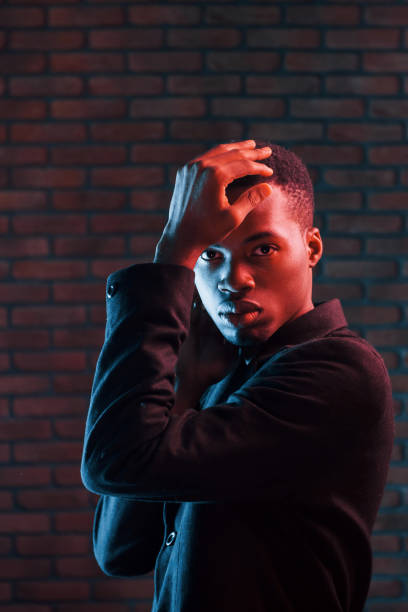 istock Futuristic neon lighting. Young african american man in the studio 1186894669