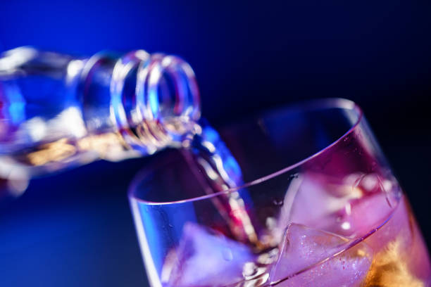 istock Pouring whiskey from bottle into glass with ice 1186894849
