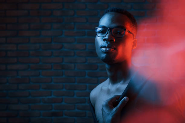 istock Light blinks. Futuristic neon. Young african american man in the studio 1186894878