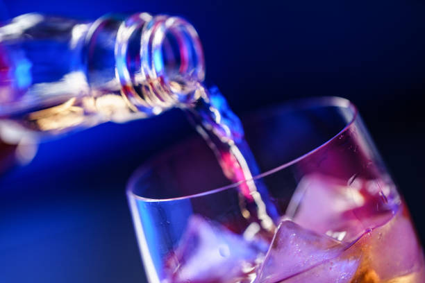 istock Pouring whiskey from bottle into glass with ice 1186895113