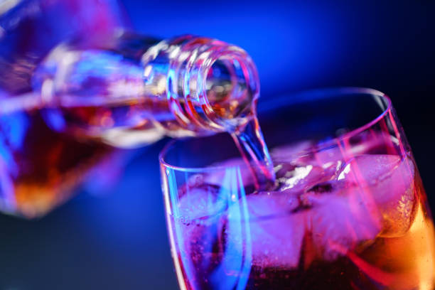 istock Pouring whiskey from bottle into glass with ice 1186896271