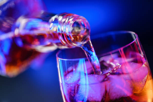 istock Pouring whiskey from bottle into glass with ice 1186896273