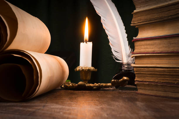 istock Scrolls of parchment, a stack of books, and a lit candle 1186896842