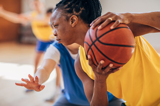 Mujer negra jugando al baloncesto en el interior photo