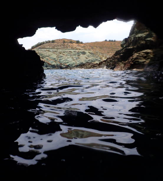 Dionysos Dionysus cave temple by Iero beach on Ikaria island, Greece with Ikarian sea cove, waves washing on coast shore rocks in summer