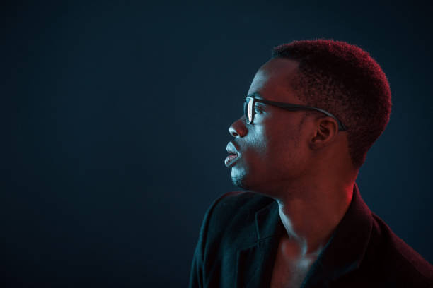 istock Futuristic neon lighting. Young african american man in the studio 1186902067