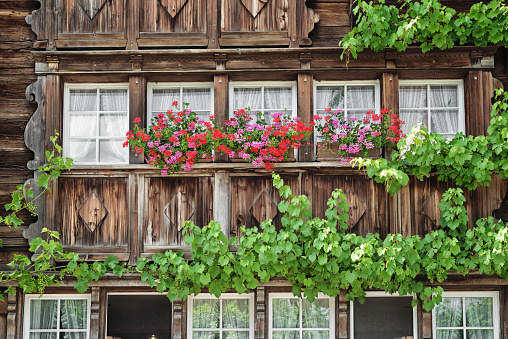 facade of a farmer house in Appenzell, Switzerland, with geraniums flowers