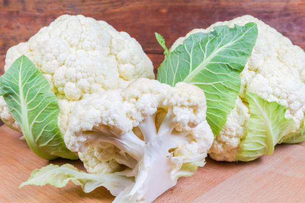 istock Fresh cauliflower on the wooden surface close-up 1186902733
