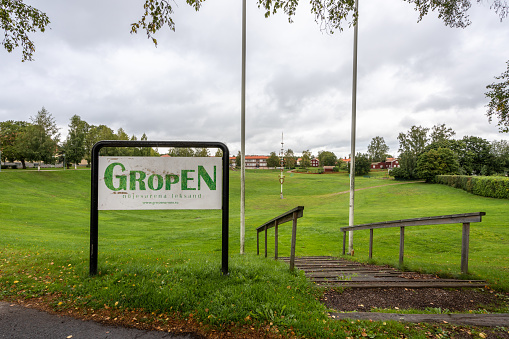 Leksand, Sweden - September 7, 2019: Autumn town landscape view of the large grassy pit Gropen were the traditional annual midsummer event take place. Gropen sign in the foreground in Leksand Dalarna Sweden September 7, 2019.
