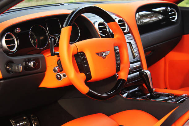 Orange luxury car Bentley Continental GT Mansory in the forest stock photo