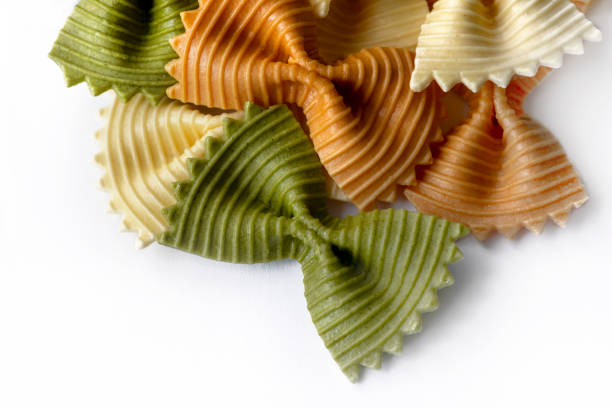 Arrangement of farfalle  ripped bow pasta,  tri-colored  close up  isolated on white selective focus background for copy space or text overlay
