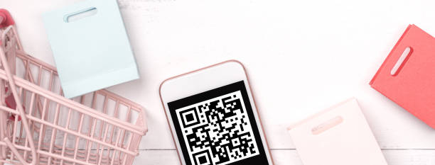 istock Abstract online shopping, mobile payment with QR code design concept element, colorful cart, paper bag on wooden table background. 1186907696