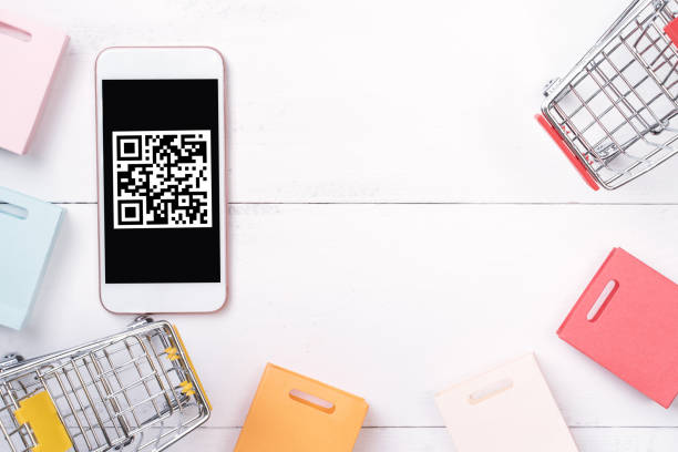istock Abstract online shopping, mobile payment with QR code design concept element, colorful cart, paper bag on wooden table background. 1186907762