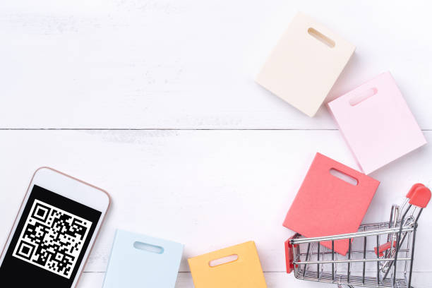 istock Abstract online shopping, mobile payment with QR code design concept element, colorful cart, paper bag on wooden table background. 1186907764
