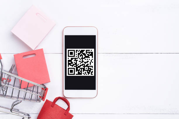 istock Abstract online shopping, mobile payment with QR code design concept element, colorful cart, paper bag on wooden table background. 1186907786