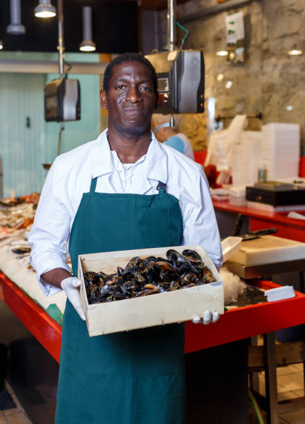 istock Positive male worker offering fresh mussels 1186908777