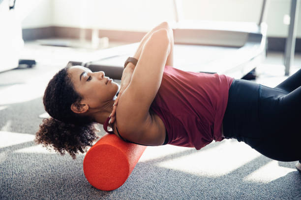 stretching her upper back - ellipse elliptical format exercising women fotografías e imágenes de stock