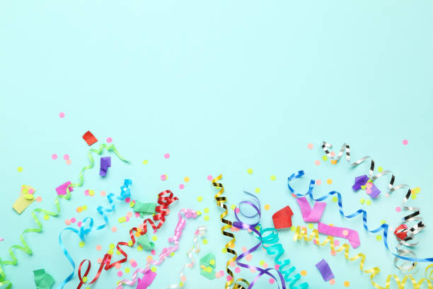 istock Colorful ribbons with confetti on blue background 1186909568