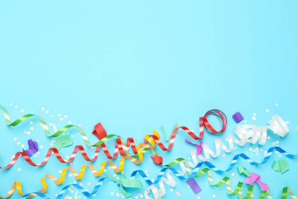 istock Colorful ribbons with confetti on blue background 1186909624