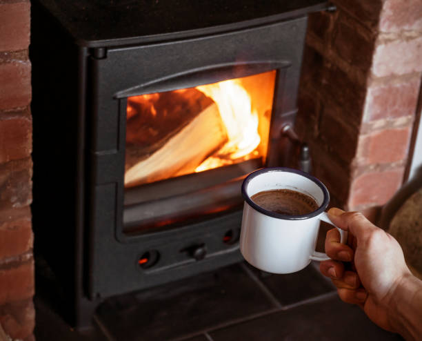istock man With Hot Drink Relaxing By Fireplace. 1186912184