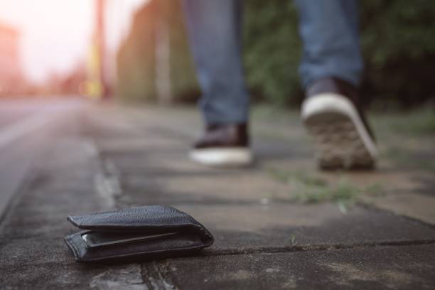 Picture of a wallet falling on the sidewalk stock photo