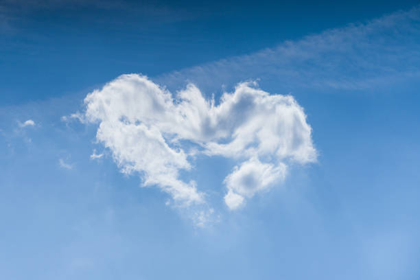 istock Cloudscape. Blue sky and white heart shaped cloud. Sunny day. 1186912557