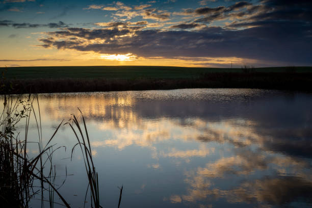 istock Vivid orange sunset reflected in a tranquil lake 1186914571