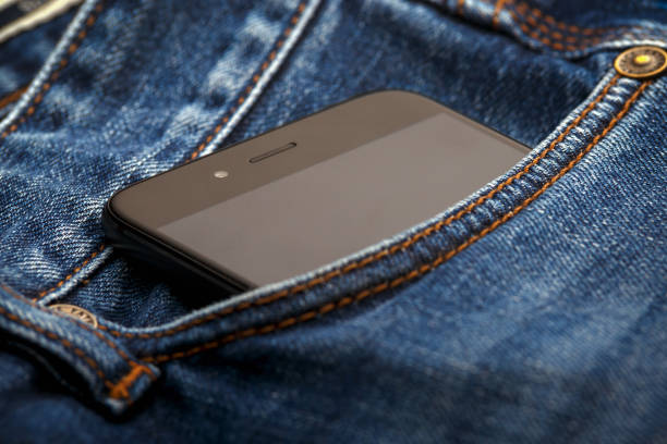 istock smartphone mobile in Blue jeans pocket with black screen. 1186914660