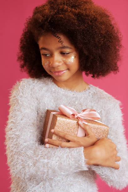 istock Cute festive girl holding a shiny gift box 1186914780