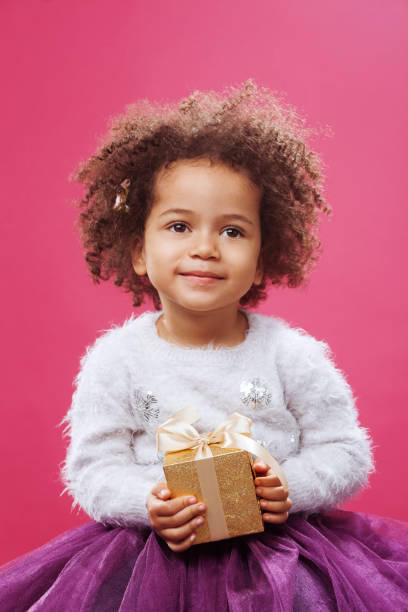 istock Cute little girl holding a shiny gift box 1186914785